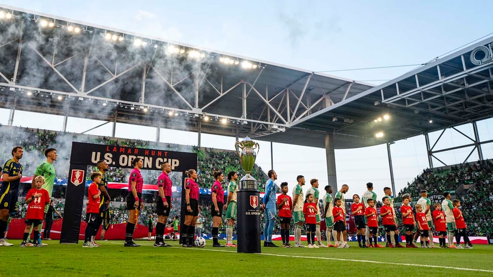Nashville SC and Austin FC players standing before start of 2025 U.S. Open Cup final, with trophy in foreground