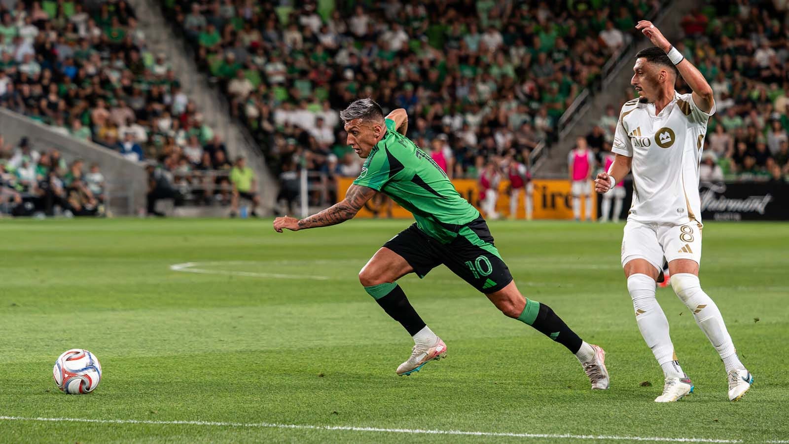 Austin FC's Myrto Uzuni runs toward ball while LAFC's Mark Delgado looks on